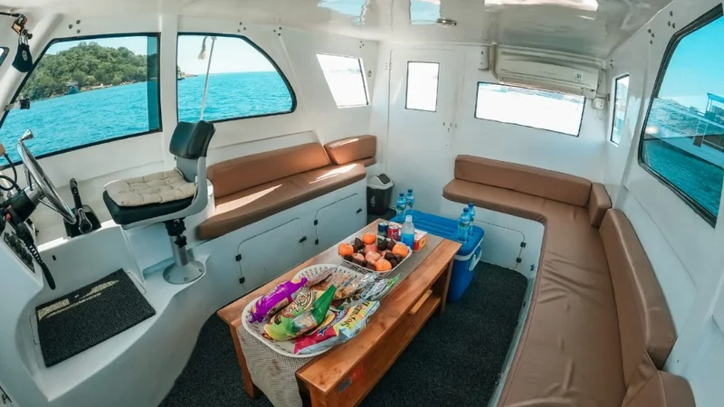 AC cabin interior speedboat full day tour Komodo Labuan Bajo — comfortable seating